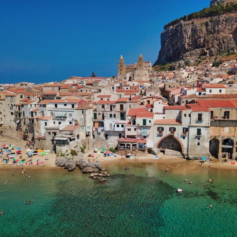 people on beach near houses during daytime